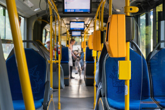 Modern bus interior with passengers and bicycle. Passengers in the city bus in the evening in Krakow. Modern public transport in Europe. Travel and tourism concept. Comfortable travel.