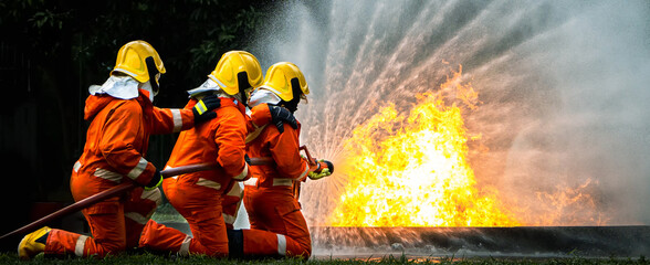 Firefighter Concept. Fireman using water and extinguisher to fighting with fire flame. firefighters...