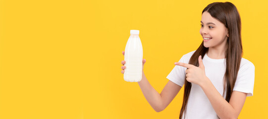 cheerful child point finger on dairy beverage product. teen girl going to drink milk. Horizontal poster of isolated child face, banner header, copy space.