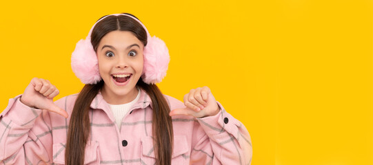 Happy kid in warm winter fur ear warmers smile pointing thumb fingers at herself, fashion. Child face, horizontal poster, teenager girl isolated portrait, banner with copy space.