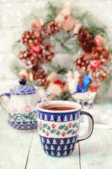Obraz na płótnie Canvas Christmas ceramic mug with hot tea. Holiday mood, New Year decorations. Selective focus.