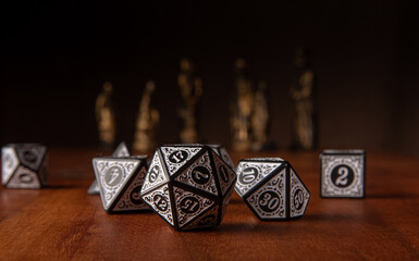 RPG dice, beautiful RPG dice on rustic wood, dark background with figures, selective focus.