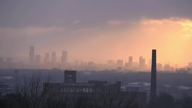 View of Manchester city skyline at sunset , with the sun rays illuminating the skyline.