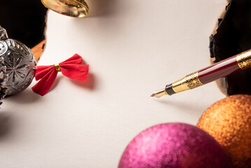 Fountain pen, a beautiful fountain pen, a blank sheet with burnt edges and Christmas ornaments, Selective focus.