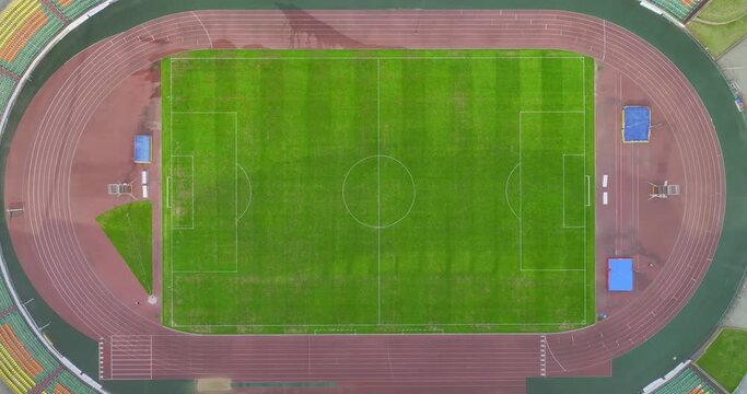 
Smooth drone shooting of a modern football field and stands. A drone flying over a sports complex on a sunny day slowly descends, slow motion