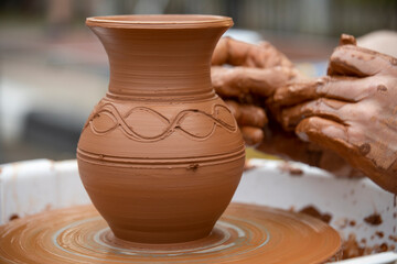 A potter makes a pot on a circle. The hands of the master create from clay. Man making ceramic pot.