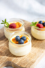 Dessert creme brulee garnished with a mint leaf and fresh blueberries and raspberries. Home recipes. Sweet snack