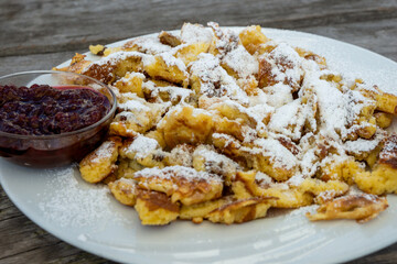 Austrian Kaiserschmarrn with raisins and cranberry jam, fresh served on a plate