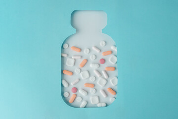 Bottle with different pills on blue background. Background for medical concept. Top view.