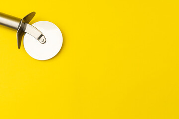 Pizza cutter on yellow background