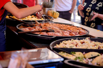 Cooking meat dishes in a summer restaurant on the street. Assorted delicious grilled meat with vegetables over charcoal barbecue.