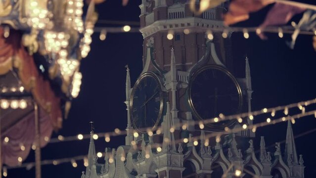 Festive garlands and a beautiful, colorful carousel against the backdrop of the Kremlin Spasskaya Tower with a clock on Red Square create a fun, New Year's mood