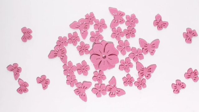 Stop motion animation of pink flowers and butterflies of different sizes turn into a kaleidoscope pattern depicting various patterns. Floral concept