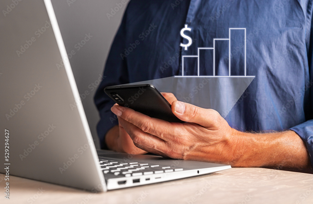 Poster man looking at growth chart at phone while working on laptop. businessman analyzing financial statis
