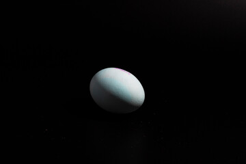 uno huevo blanco de gallina, sobre fondo negro 