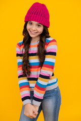 Fashion happy young woman in knitted hat and sweater having fun over colorful blue background. Happy teenager, positive and smiling emotions of teen girl.