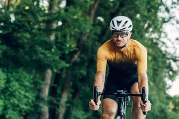 Athletic man in sport clothes riding a bike in the nature
