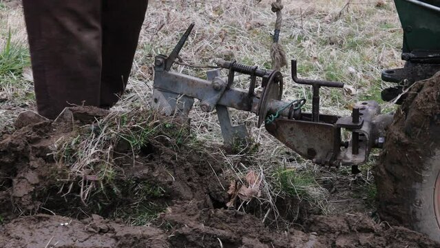 Man Working on his Agricultural Field With a Motor Cultivator in Winter close up on Field and Machinery Work