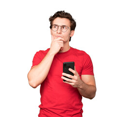 Thoughtful young man using his mobile phone