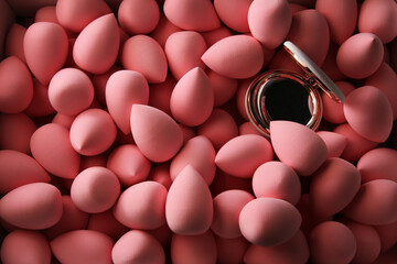 beauty background a bunch of pink gentle makeup sponges and a mirror dark key