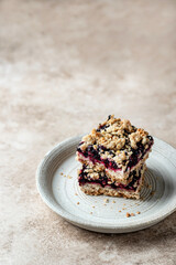 Vegan baked oatmeal squares with fresh blueberry on beige background with text space