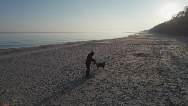 Playing with the dog on an empty bay at sunrise.