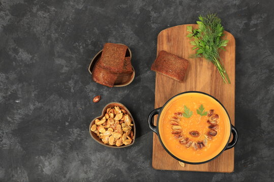 Pumpkin and zucchini cream soup with roasted seeds and toast,traditional autumn vegan food,healthy natural breakfast with place for recipe,advertising for cafe,restaurant,business card,