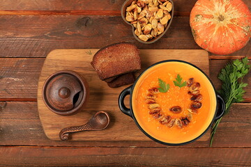 Pumpkin and zucchini cream soup with roasted seeds and toast,traditional autumn vegan food,healthy natural breakfast,advertising for cafe,restaurant,business card,