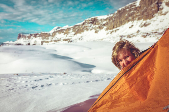 Portrait of happy woman peeking through tent at Grand Teton National Park during winter