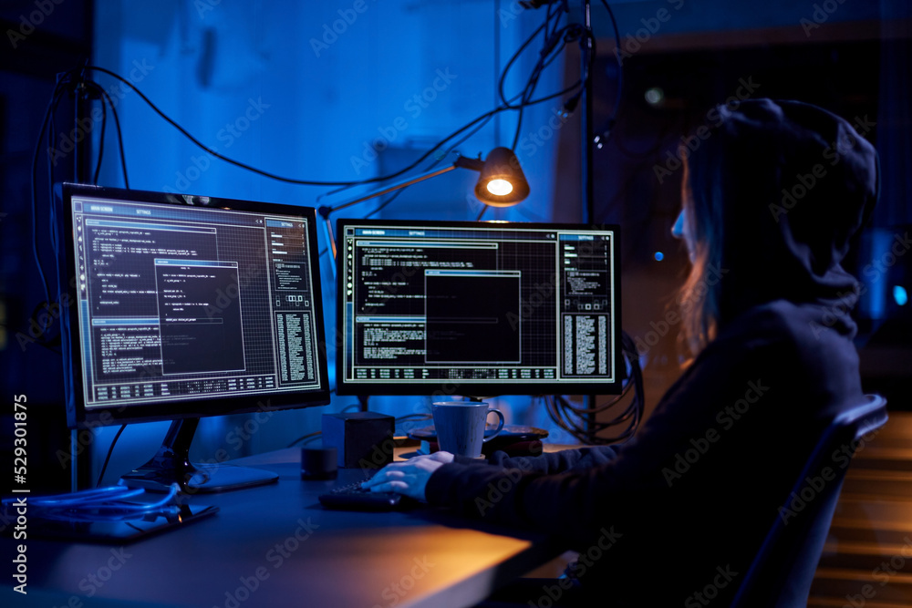 Poster cybercrime, hacking and technology concept - female hacker in dark room writing code or using comput