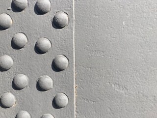 A group of round rivet heads on a grey painted metal surface