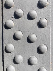 A group of round rivet heads on a grey painted metal surface