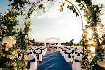Chairs arranged for ceremony seen through wedding arch