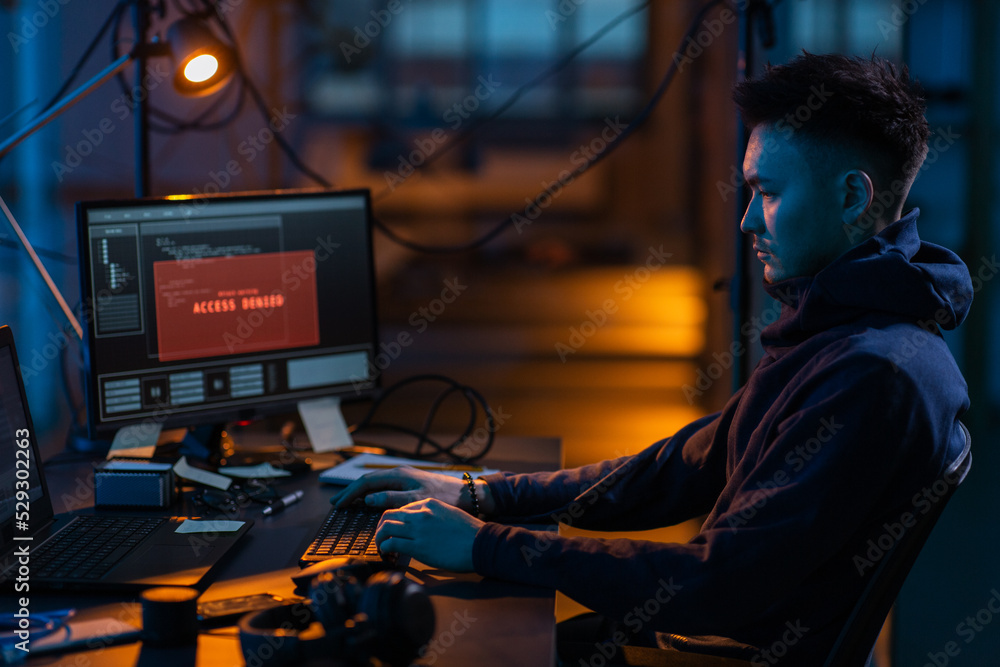 Poster cybercrime, hacking and technology concept - male hacker in dark room writing code or using computer