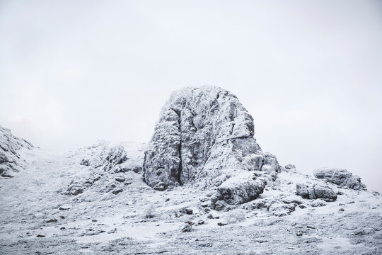 Snow covered rocks against clear sky