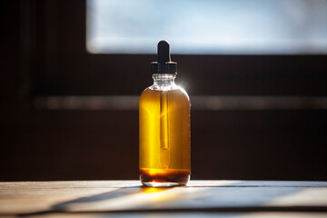 Close-up of oil bottle on wooden table at home