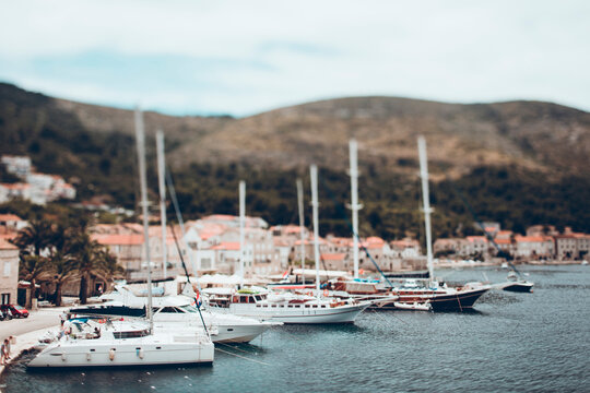 Tilt-shift image of boats moored at lake in town