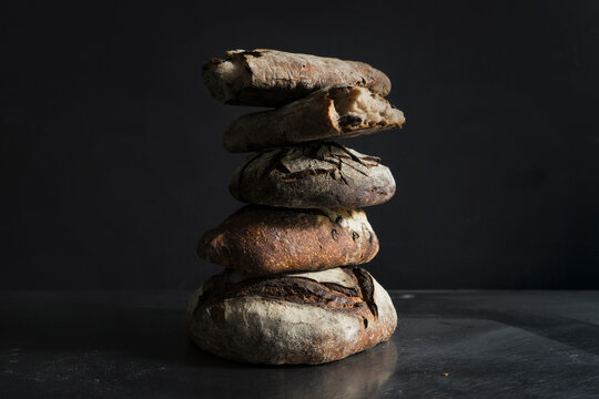 Stack of sourdough bread on table against black background
