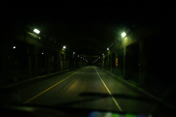Illuminated tunnel seen through car windshield