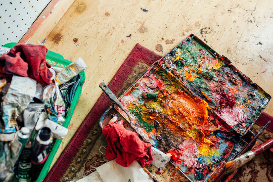 High angle view of colorful messy palette on table at workshop