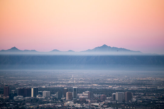 Aerial view of cityscape against mountains and clear sky during sunset