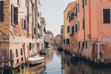 Boats moored in canal by abandoned buildings