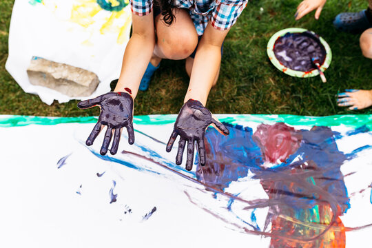 High angle view of boy with painted hands at yard