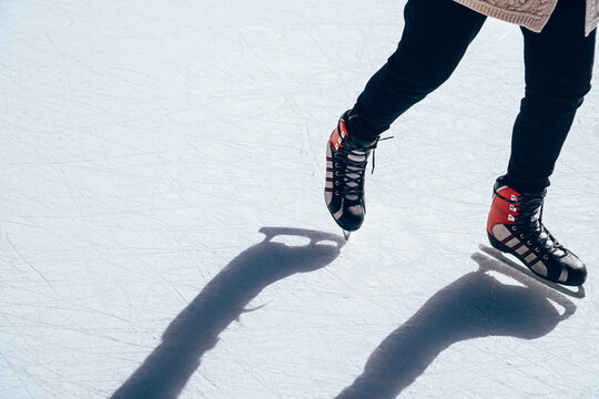 Low section of woman ice-skating on snow covered field