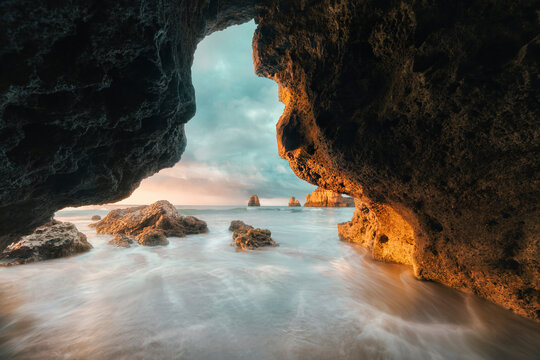 Scenic view of ocean against sky seen through cave