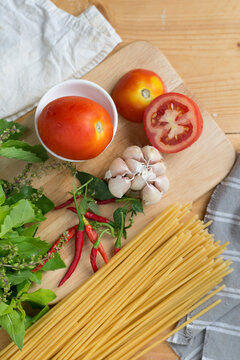 Close-up of raw bucatini with ingredients on table