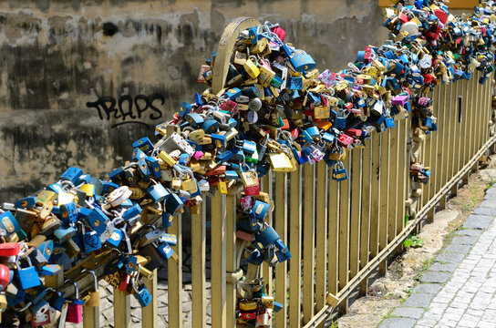 Various love locks on metallic railing of Charles Bridge in city
