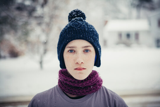 Portrait of teenage boy standing at yard during winter