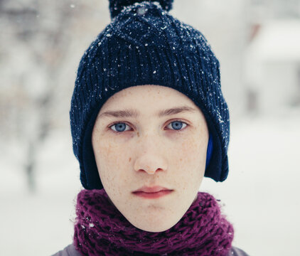Close-up portrait of teenage boy standing at yard during winter