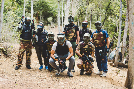 Portrait of army soldiers with weapons in forest during training